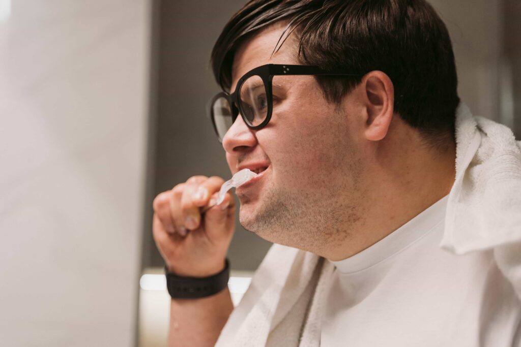 man with braces brushing and flossing